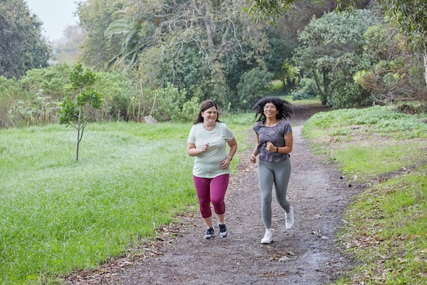 a couple of women running down a dirt road